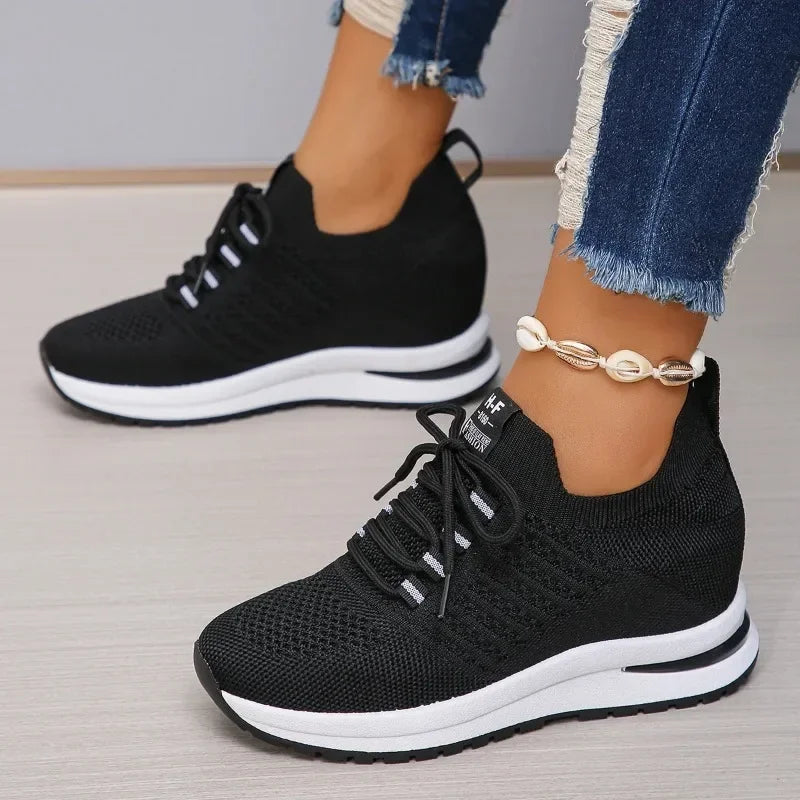 Black lightweight walking shoes with white soles worn with ripped blue jeans and shell anklet