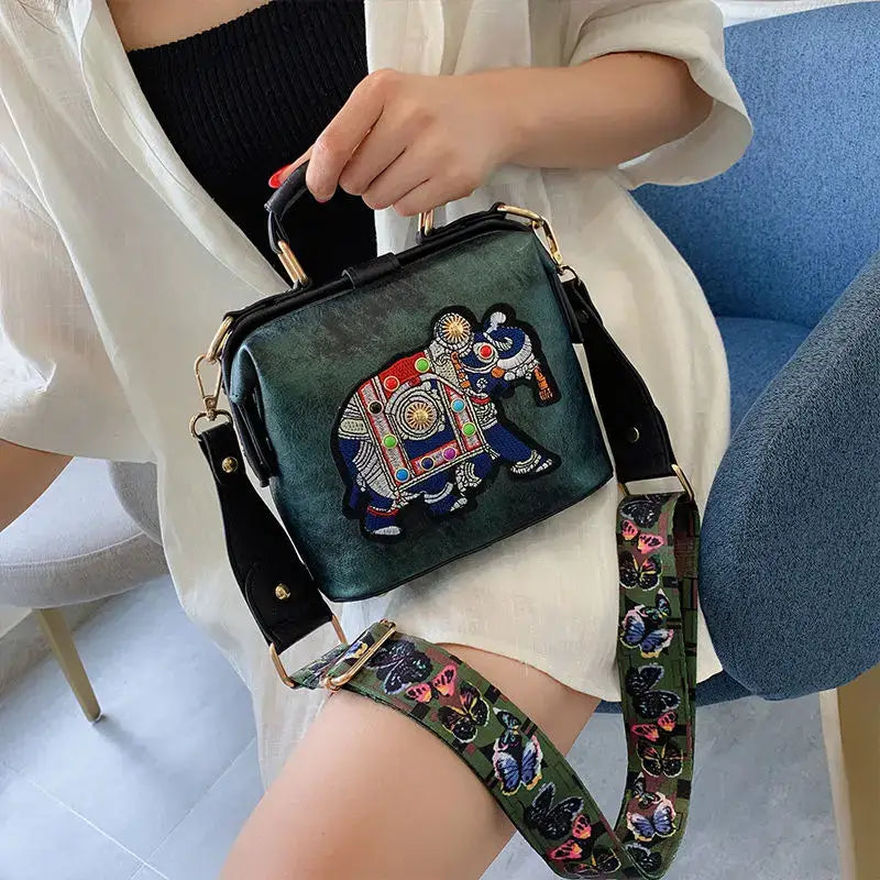 Luxury embroidered crossbody bag featuring an elephant design and versatile shoulder strap