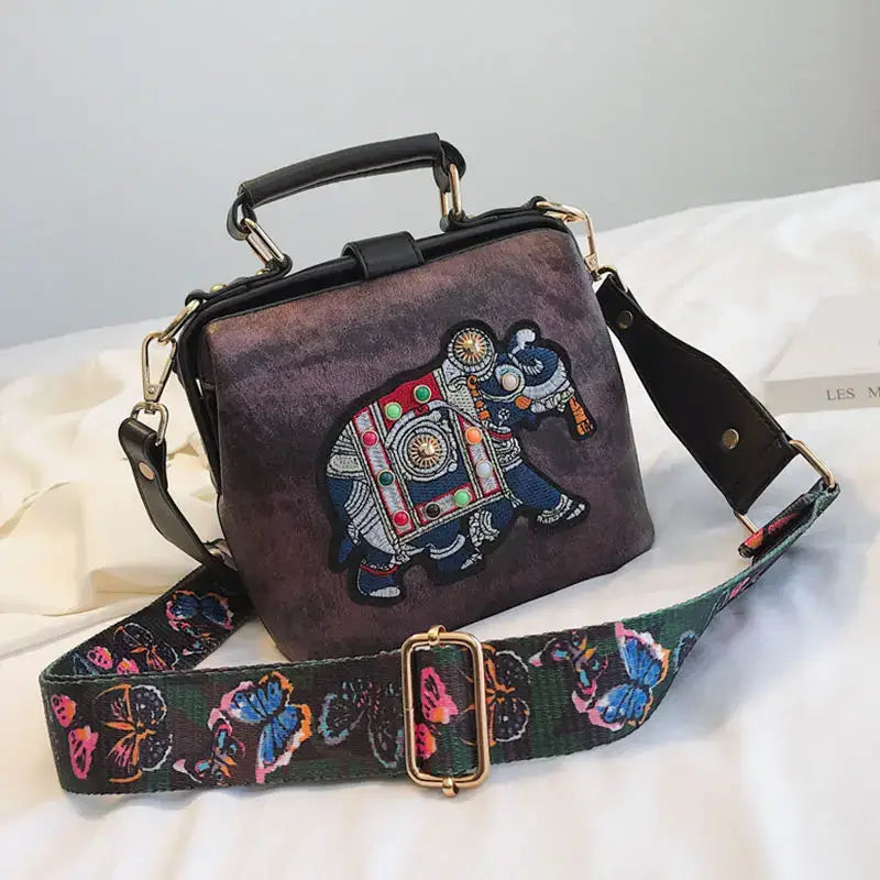 Luxury embroidered crossbody bag featuring an elephant design and adjustable strap for stylish carry