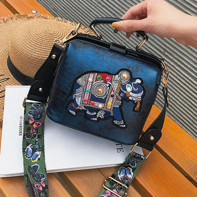 Luxury embroidered crossbody bag featuring a colorful elephant design and stylish detachable strap