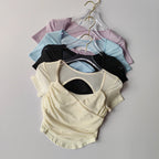 Collection of padded yoga shirts for women in various colors including black, blue, lavender, and cream
