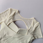 Light cream padded yoga shirts for women with a stylish open back design