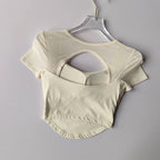 Cream-colored padded yoga shirts for women with a stylish back cutout design