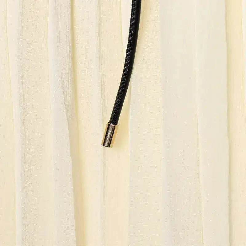 Close-up of cream pleated chiffon midi skirt with black adjustable drawstring detail