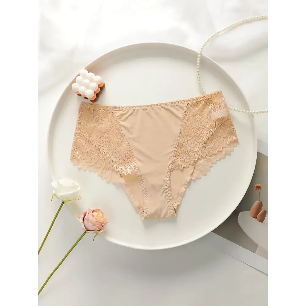 Beige plus size lace underwear for women with floral lace detail laid flat on white plate