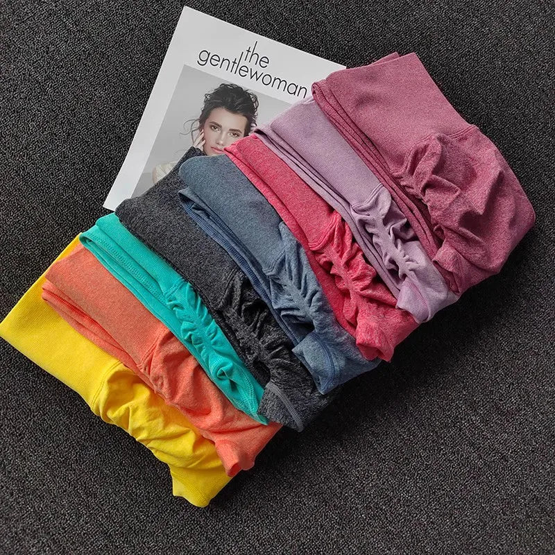 Colorful stack of push up leggings for women in various shades laid on a magazine backdrop