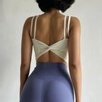 Back view of a stylish cream push up sports bra for women with a twist design and adjustable straps