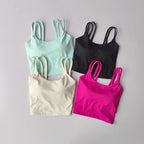 Set of four push up sports bras for women in mint green, black, cream, and pink colors