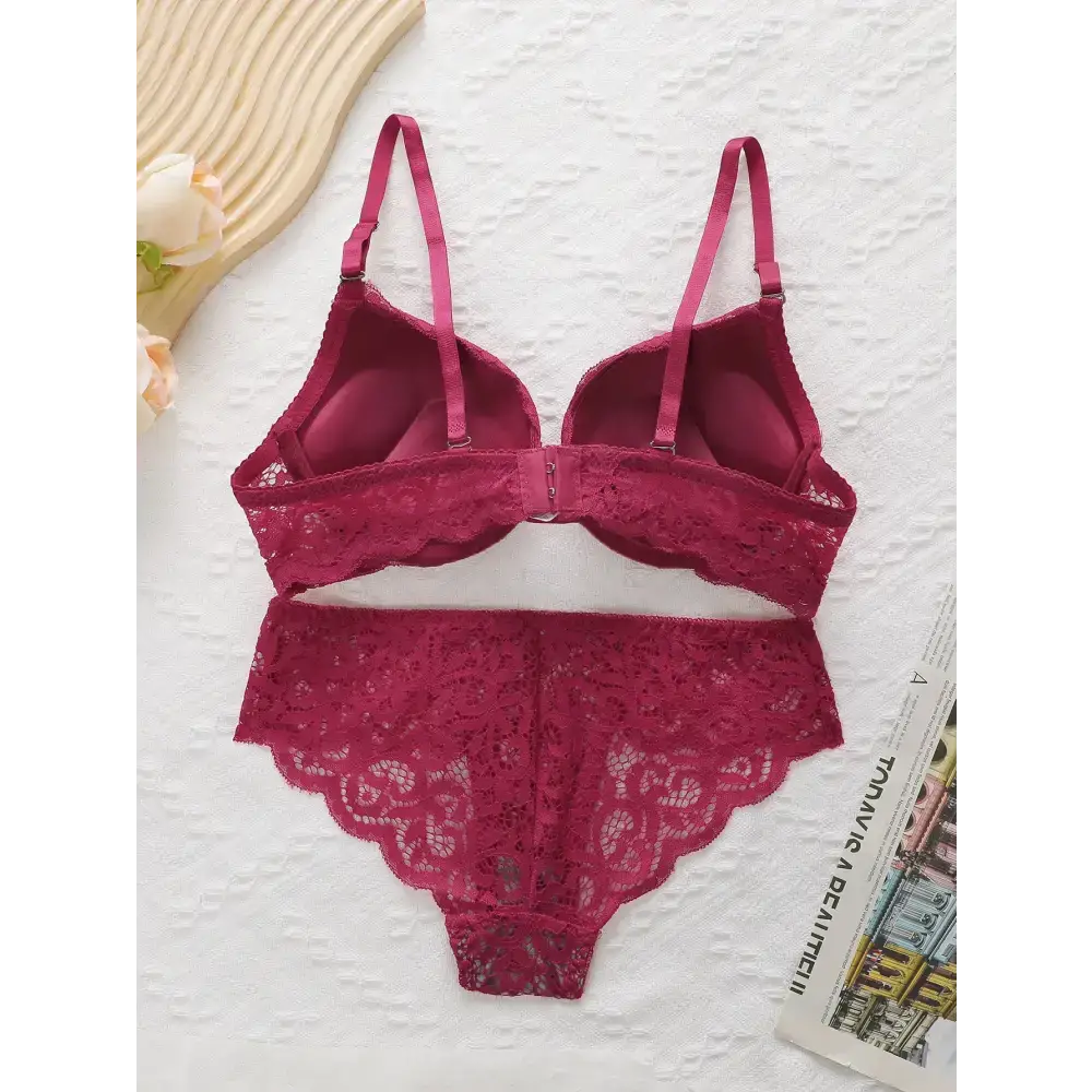 The Lady's Haven Boutique burgundy lace push up underwire bra and panty set laid flat on white textured surface