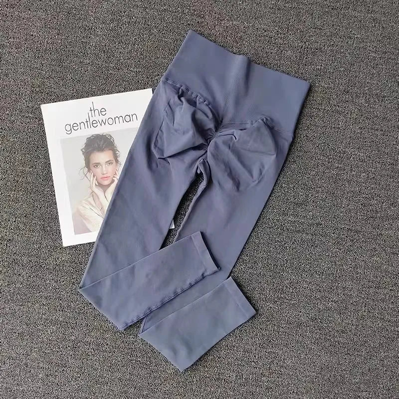 Quick dry sport leggings in grey color laid flat next to a fashion magazine for stylish workout wear