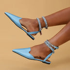 Light blue flat heel rhinestone ankle strap sandals from The Lady's Haven Boutique on model feet