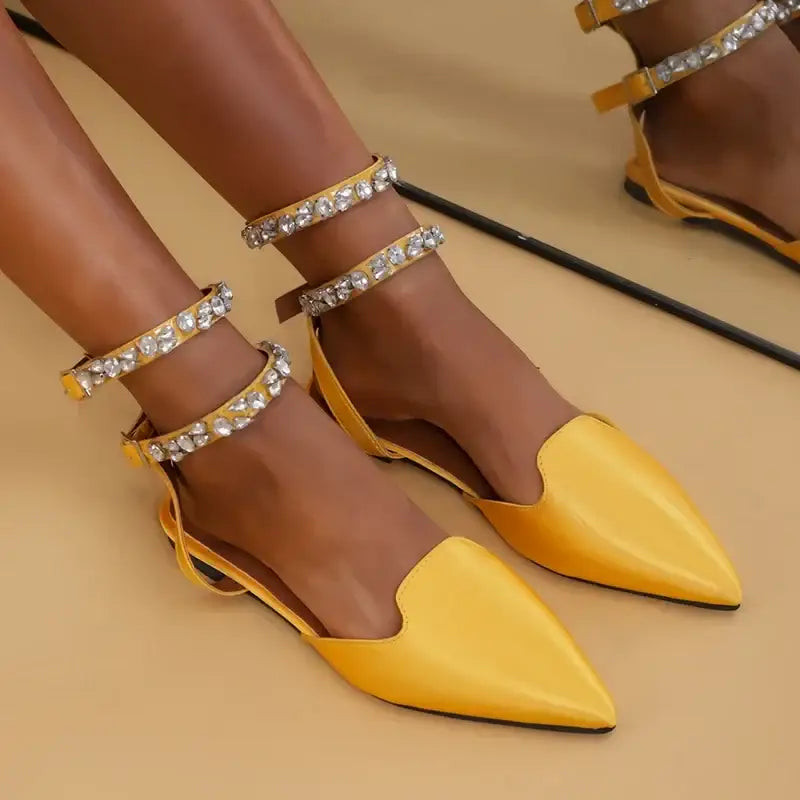 Yellow flat heel rhinestone ankle strap sandals from The Lady's Haven Boutique on model's feet