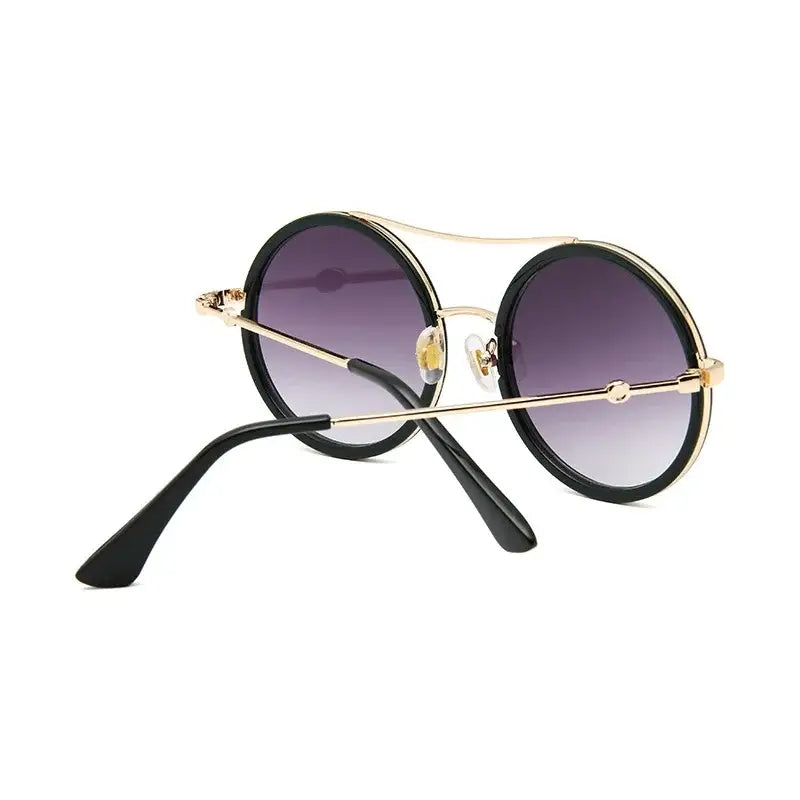 Stylish round sunglasses with designer flair featuring a chic black frame and gradient lenses