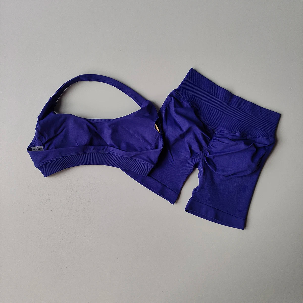 Purple seamless yoga suit for women featuring a supportive bra and matching shorts