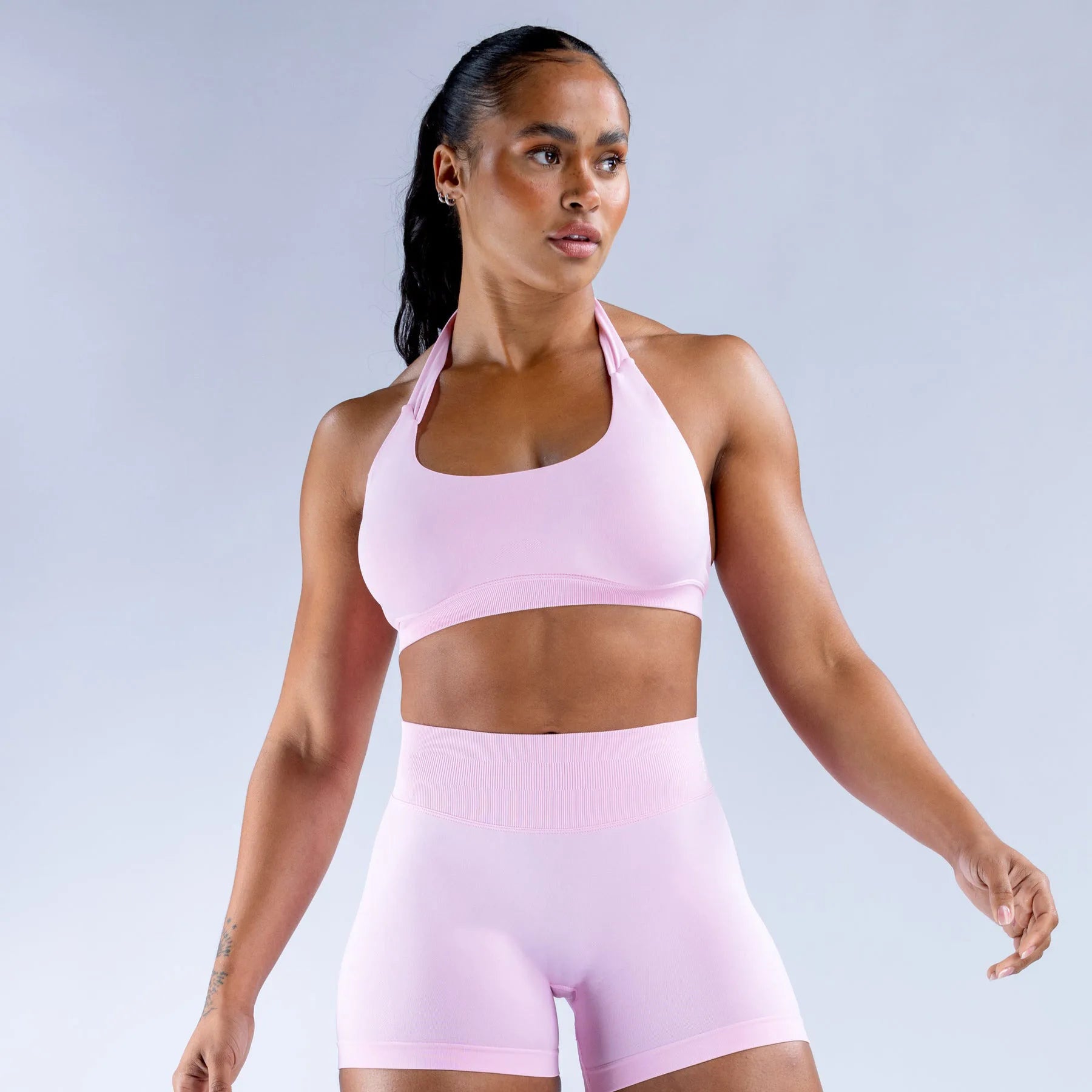Pink seamless yoga suit for women featuring a halter top and high-waisted shorts for comfort and style