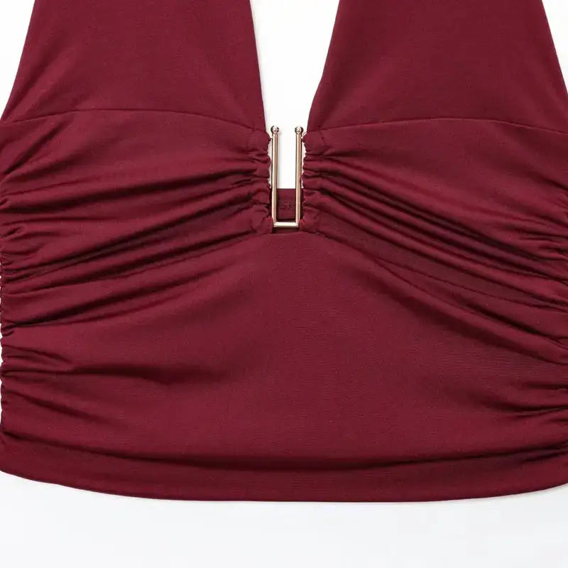 Close-up of burgundy pleated off shoulder crop top with ruched detailing and metal clasp