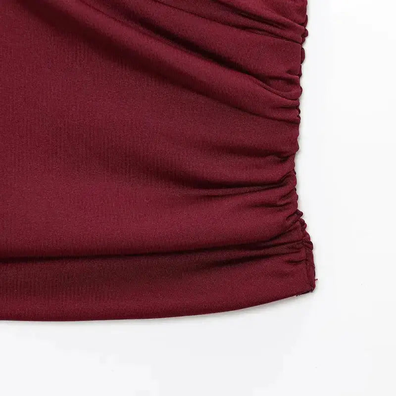 Close-up detail of burgundy pleated off shoulder crop top fabric texture and stitching