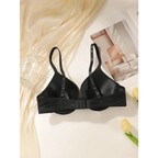 Black sequin lingerie bra with steel ring and adjustable straps laid on cream fabric