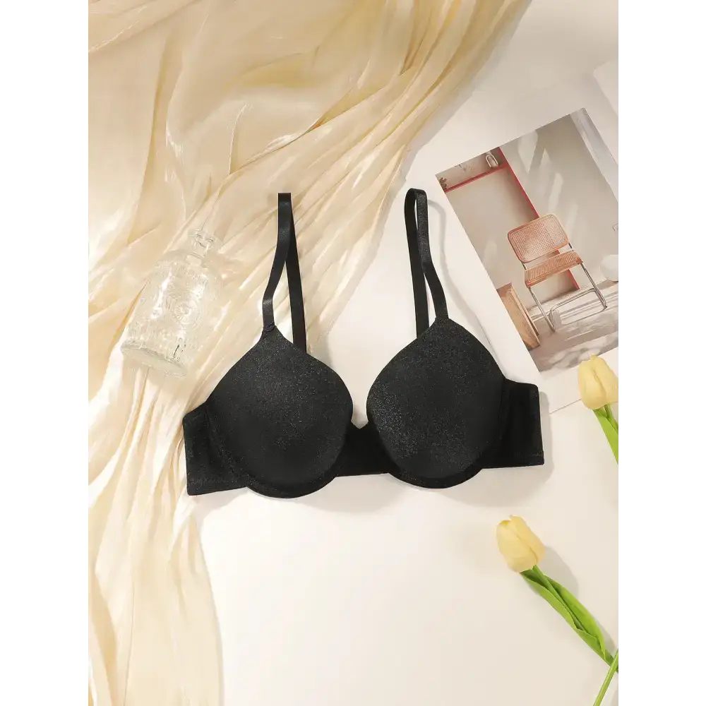 Black sequin lingerie bra with steel ring featuring adjustable straps displayed on fabric backdrop