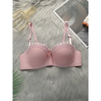 Pink sexy embroidered flower bra with adjustable straps laid on soft gray surface