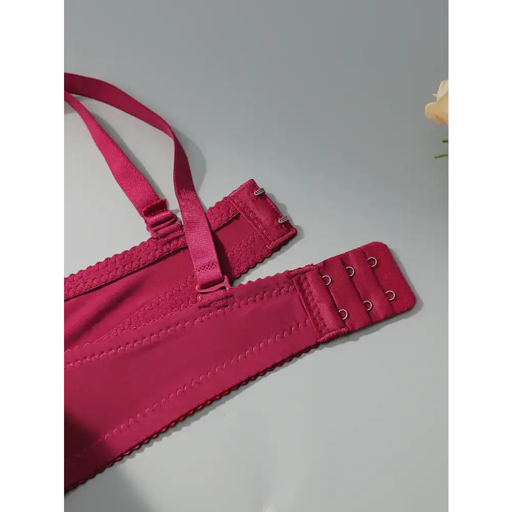 Close-up of a sexy embroidered flower bra in deep pink with adjustable straps and hook closures