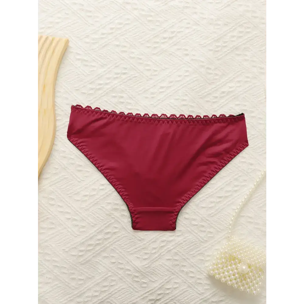 Red panties from sexy embroidered lace lingerie set by The Lady's Haven Boutique on white textured background