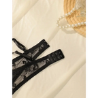 Black sexy lace lingerie set with floral pattern and adjustable straps on white fabric
