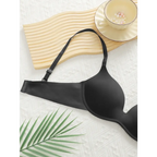 Sexy lingerie black bra from The Lady's Haven Boutique displayed on textured surface with plant and cup