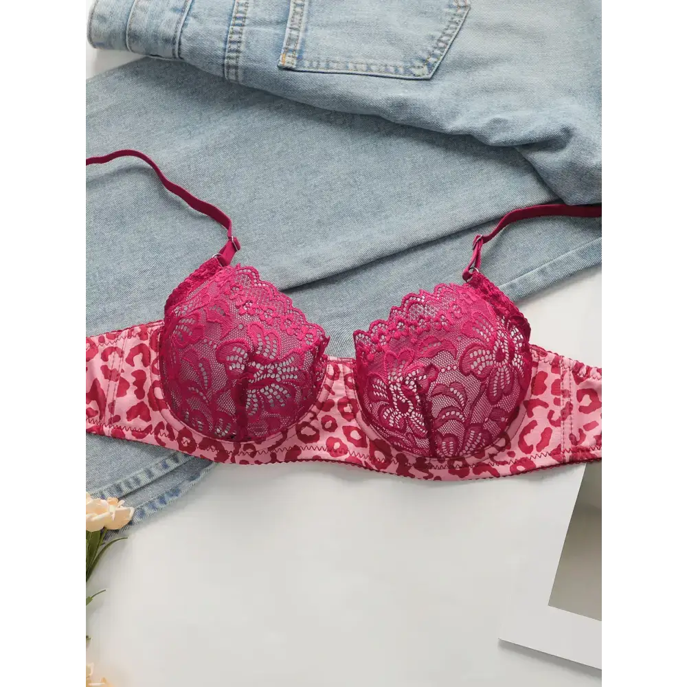 Sexy pink leopard print lingerie set bra with lace cups laid on denim fabric