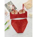 Sexy red bra and panty set from The Lady's Haven Boutique laid flat with decorative flowers and accessories