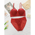 Sexy red bra and panty set laid flat with pearl necklace and flowers for The Lady's Haven Boutique