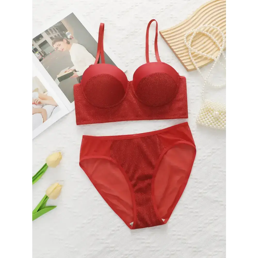 Sexy red bra and panty set laid flat with pearl necklace and flowers for The Lady's Haven Boutique