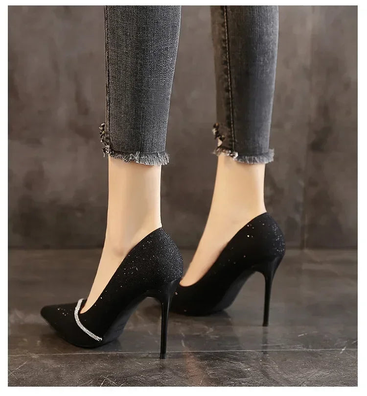 Black single strap stiletto heels with sparkling detail worn with frayed hem jeans