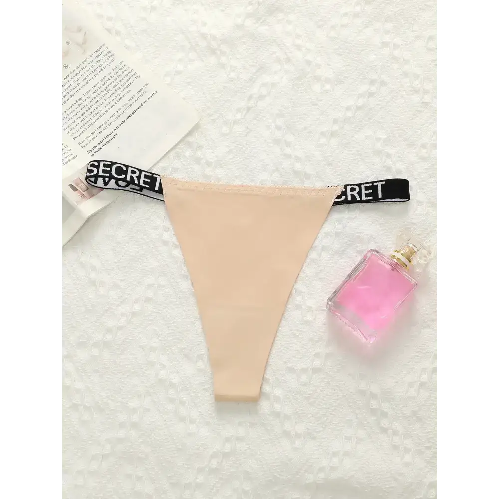 Beige thong underwear with black elastic waistband featuring SECRET text for small chest lifting underwear