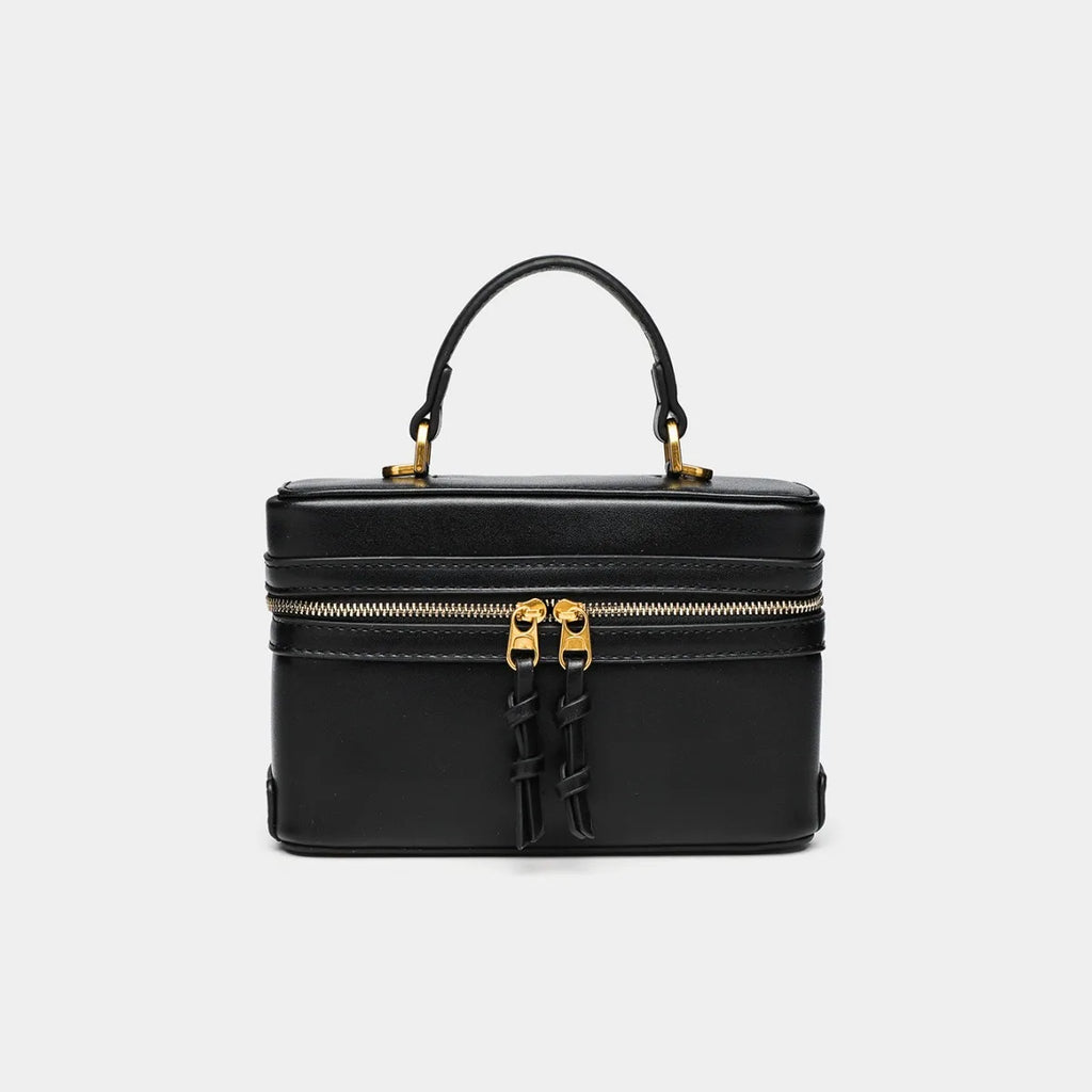 Black small square bag with gold zipper and top handle from The Lady's Haven Boutique