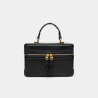 Black small square bag with gold zipper and top handle from The Lady's Haven Boutique
