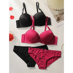 Black and pink solid color bra and panty set from The Lady's Haven Boutique laid out on a white surface