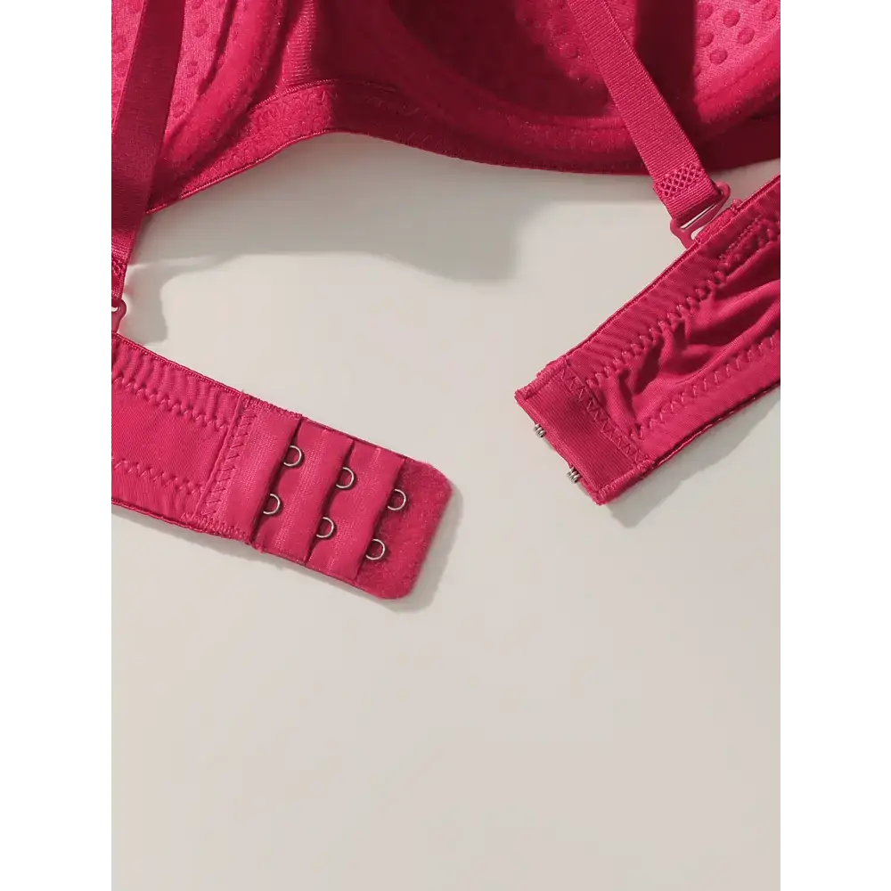 Close-up of vibrant red solid color bra and panty set showing adjustable hook and eye closure