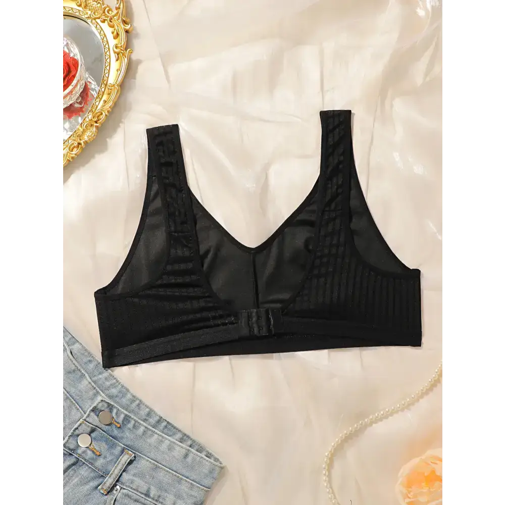 Black solid color striped plus size lingerie bra from The Lady's Haven Boutique laid flat on fabric