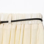 Close-up of a cream pleated chiffon midi skirt waistband with a thin black belt from The Lady's Haven Boutique