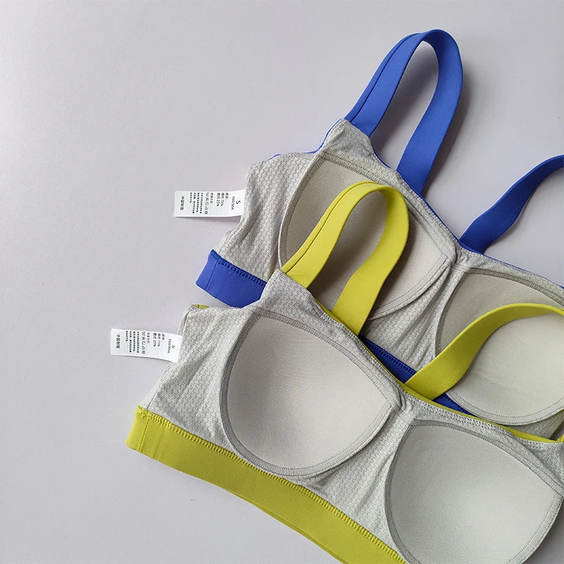 Stylish two piece workout clothing for women featuring a color block sports bra in gray, blue, and yellow