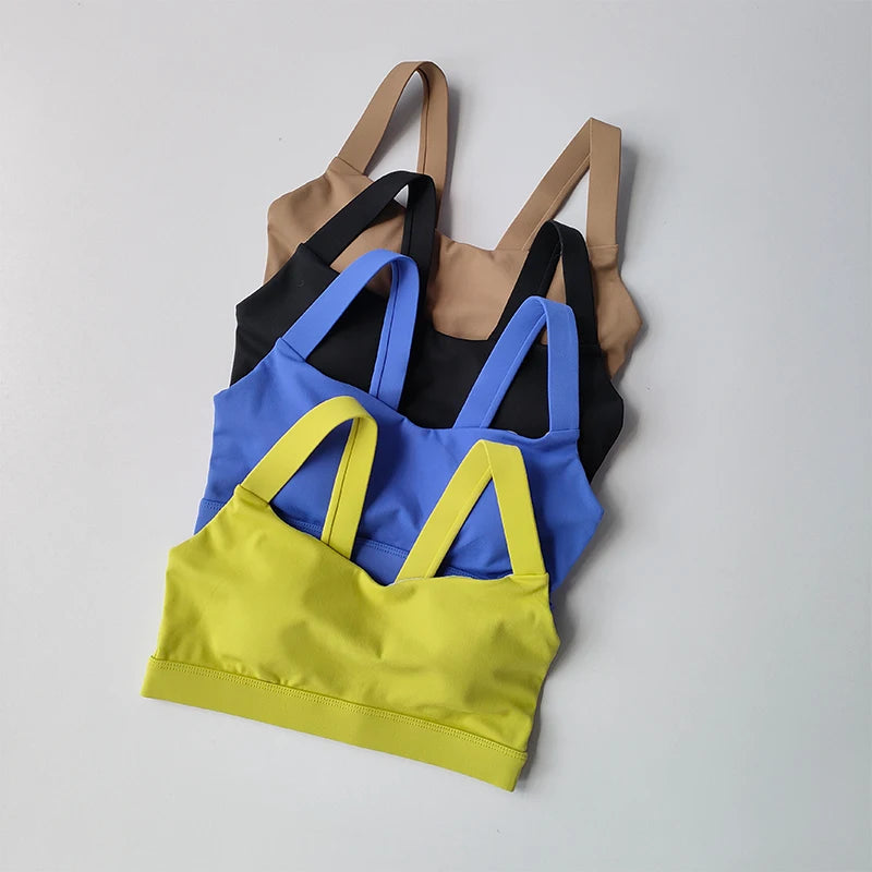 Stylish two piece workout clothing for women featuring a set of three colorful sports bras in black, blue, and yellow
