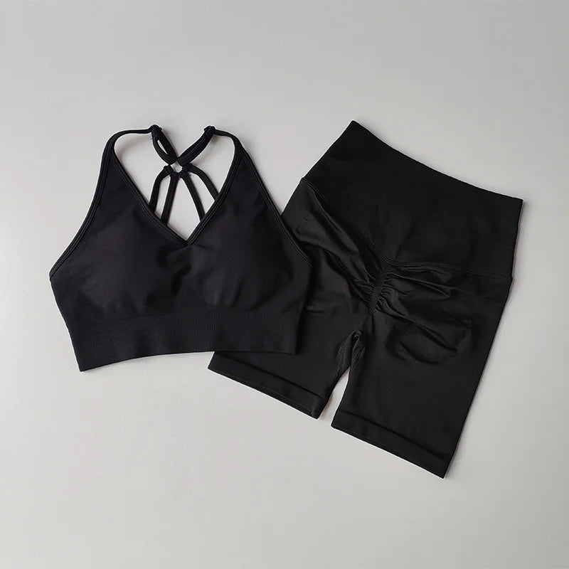 Stylish black two piece workout outfits featuring a crisscross sports bra and high-waisted shorts