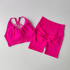 Bright pink two piece workout outfits featuring a stylish crisscross sports bra and matching high-waisted shorts