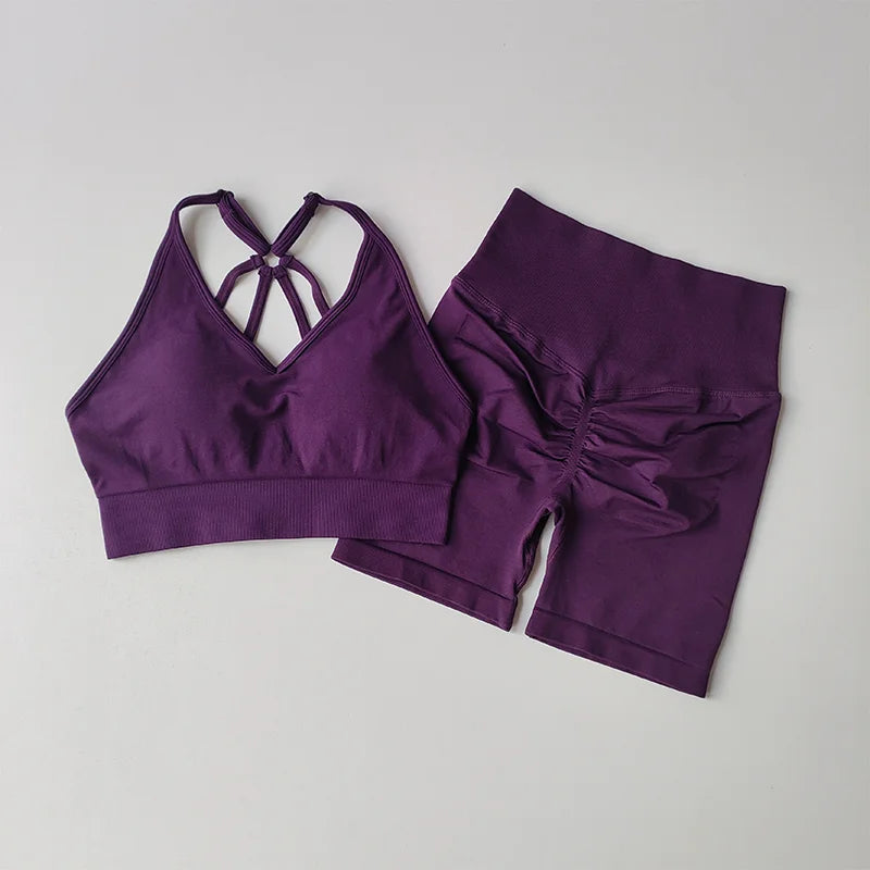 Purple two piece workout outfits featuring a crisscross sports bra and high-waisted shorts
