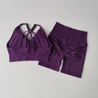 Purple two piece workout outfits featuring a strappy sports bra and matching high-waisted shorts