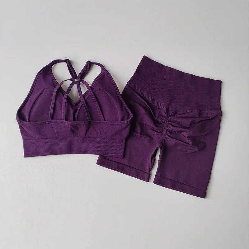 Purple two piece workout outfits featuring a strappy sports bra and matching high-waisted shorts