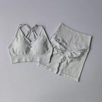 Stylish two piece workout outfits in light gray featuring a crisscross sports bra and high-waisted shorts