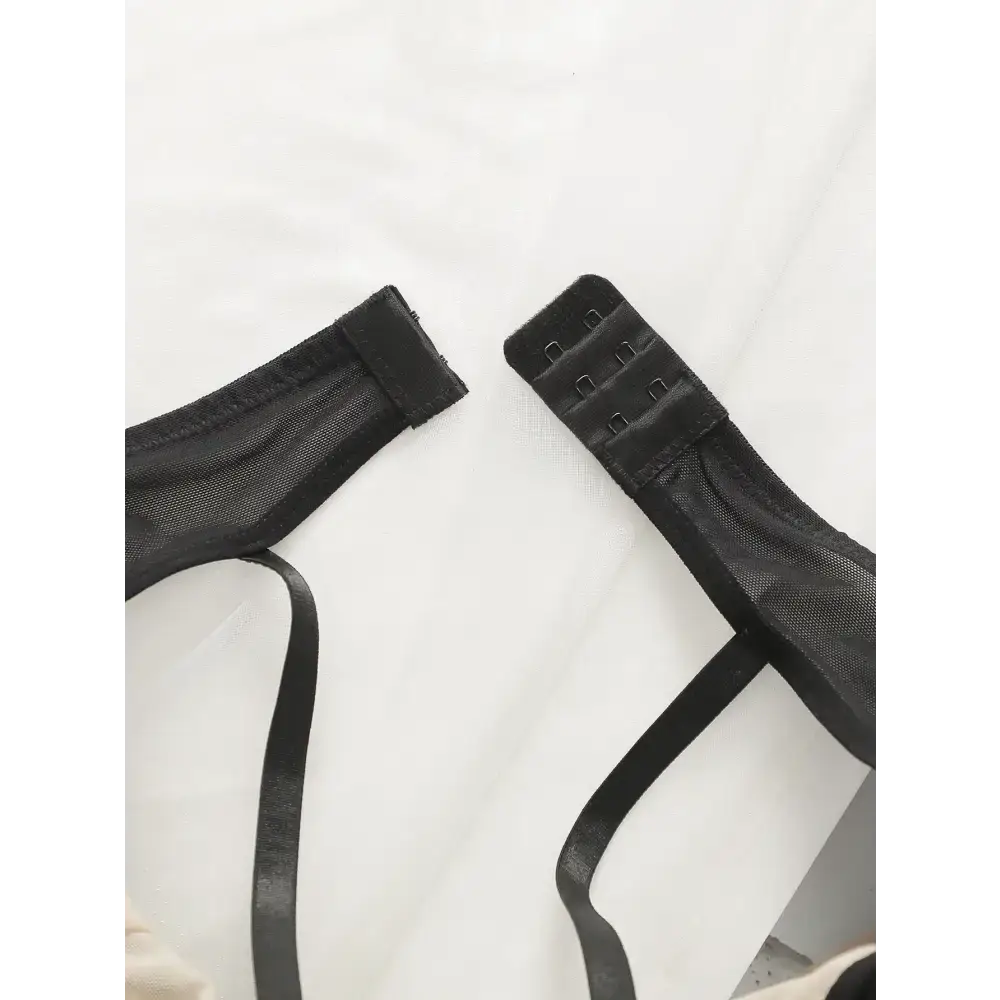 Black breathable patchwork lingerie for women with adjustable strap hooks on white background