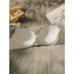 White close fitting floral bra and panty set laid open on a gray faux fur surface